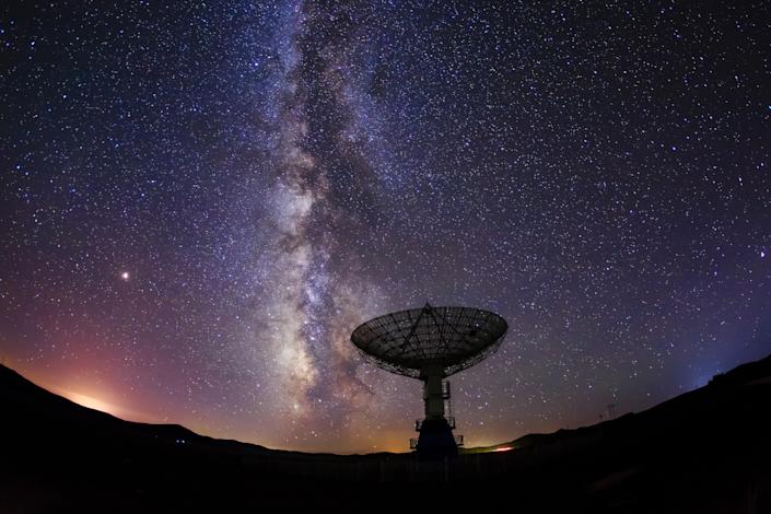 Radioteleskop och Vintergatan på natten